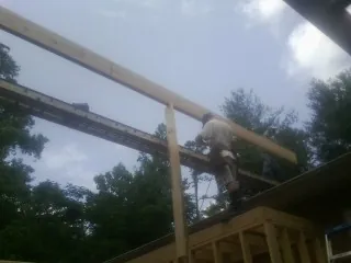 Carpenter setting a ridge beam over a new addition frame — Ice Dam Removal by Roofing Brothers in Vader