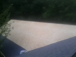 New OSB roof sheathing installed beside an existing shingle roof in Vader