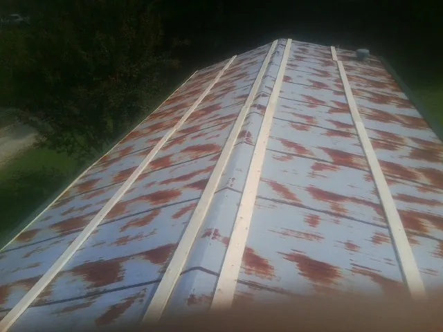 Rusted metal roof panels with new wood purlins before replacement — Storm Damage Roof Repair in Vader by Roofing Brothers